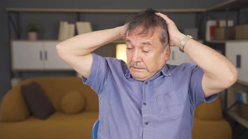 Frustrated Man Grasping His Head Indoors