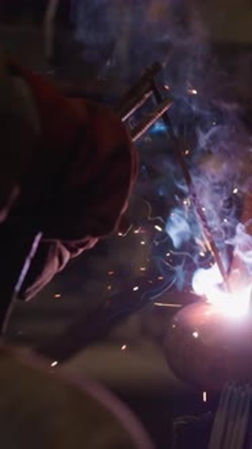 Welder Attaches Pipes to Foundation with Machine at Plant