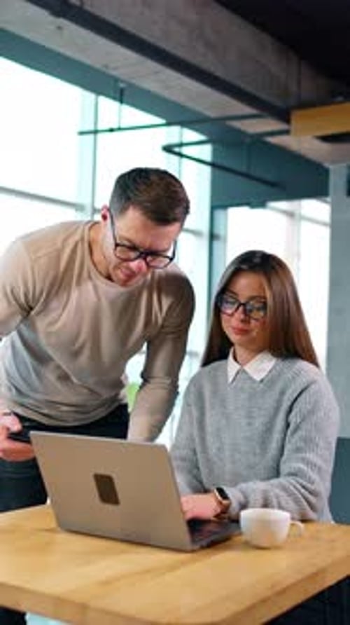 Business Colleagues Discussing Work on Laptop in Office