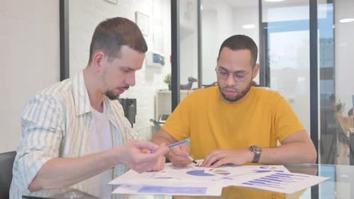 Men Collaborating on Business Data in Office
