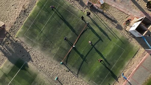 Friends Playing Foot Tennis Ball on the Shores of the Mediterranean Sea Aerial View Camera Down 2 By