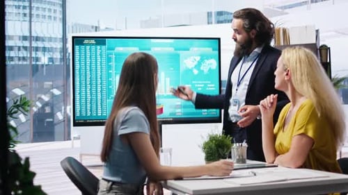 Professionals Discussing Data on Display in Modern Office