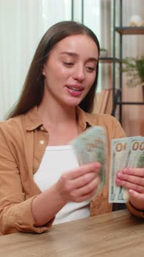 Young Woman Counting Money Dollars Cash Satisfied with Salary Earnings Celebrating Financial Success