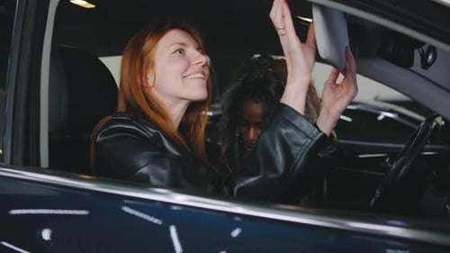 Two Women and a Car Salesman in Showroom