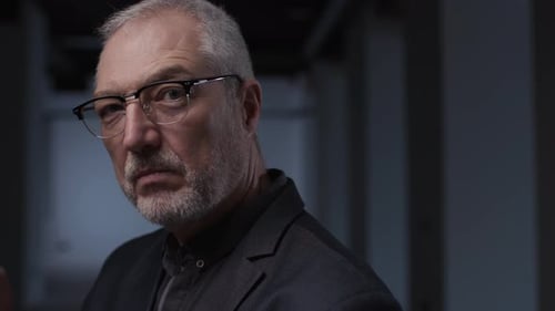 Man in Suit Takes Off Glasses Indoors