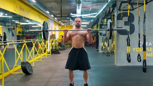 Hübscher Bodybuilder hebt die Langhantel