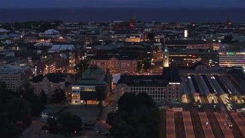 Aerial Evening Shot of Urban Borough and Central Train Station with Illuminated Platforms Helsinki