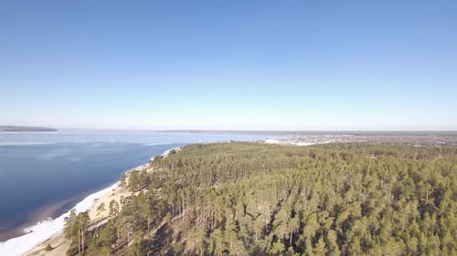 Large and wide river near forest and city. Panoramic view of river landscape. Spring.