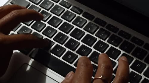 Eine Nahaufnahme einer Frau, die auf ihrem Laptop tippt, während sie von zu Hause aus arbeitet