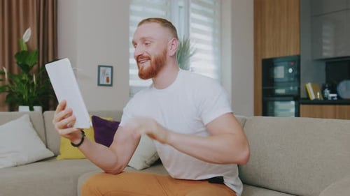 Man Video Calling on Tablet in Modern Home