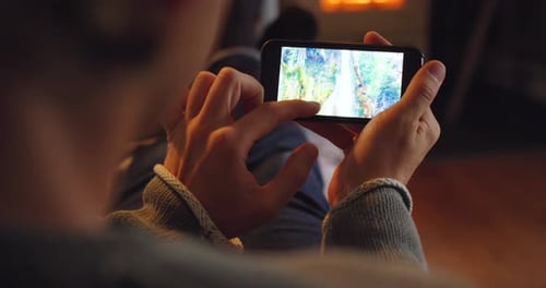 Person Scrolling Through Phone at Home