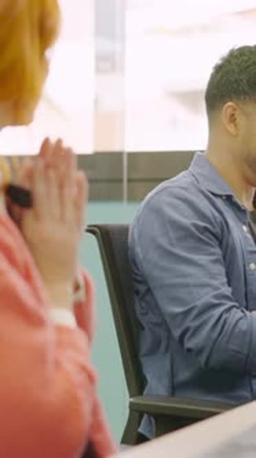 Des collègues sourient tout en travaillant ensemble avec des ordinateurs