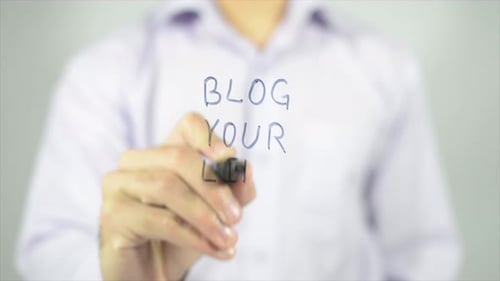 Hand Writes 'Blog Your Life' on Glass