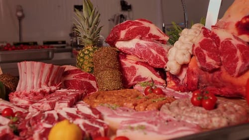 Showcase with ready to sell meat ribs and seasoned chunks at butchers store.