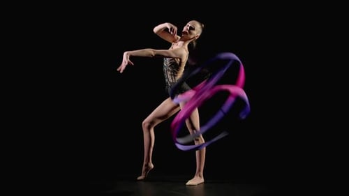Hábil y encantadora gimnasta rítmica con cinta practicando elementos en espiral