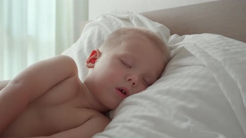 Child Sleeping Soundly on White Pillow
