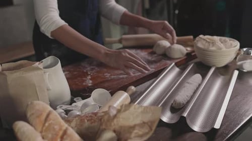 Chef rolls a ball of dough to hand make bread at bakery