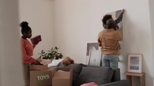Family Unpacking Stuff and Hanging Painting after Moving