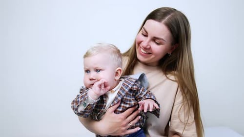 Loving Mother Holding Cute Baby Indoors