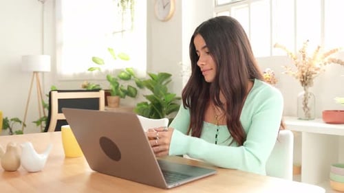 Woman Uses Laptop and Mobile Phone at Home