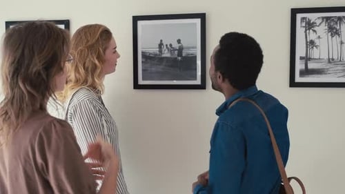People Discussing Photo Exhibition in Art Gallery