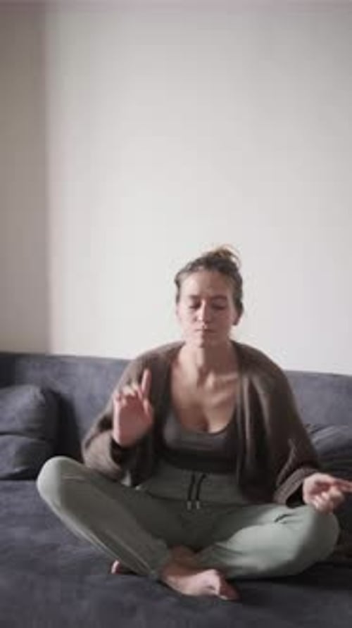 Woman Sits on Sofa Doing Finger Exercises