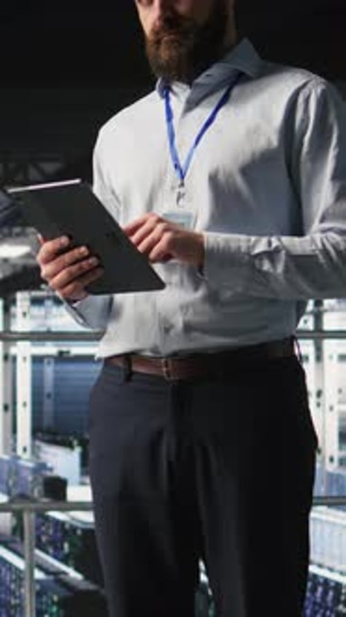 Vertical Video Portrait of Smiling Engineer in Data Center Monitoring AI LLM Visualization