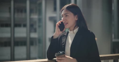 Business Woman Talking on Phone Holding Coffee