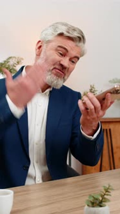 Mature Man Explaining Something On His Mobile Phone