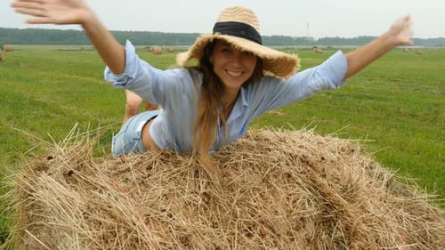 Happy Young Woman, Running On Grass Field With Haystacks. Pretty Girl In Gets Fun On Farmer Field