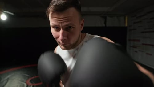 Intense Young Man Boxing with Gloves, Close Up