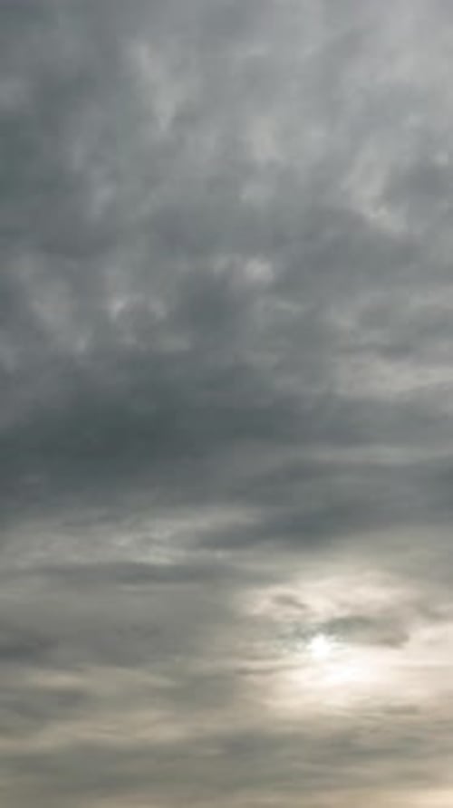 Vertical Video of Overcast Sky with Sun Through Stormy Clouds