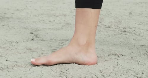 Bare Feet Walk on Dry Ground with Cracks Side View Close Up