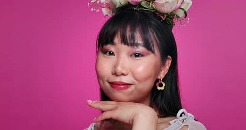 Woman, face and Asian beauty or cosmetics in studio with flower crown for pink background