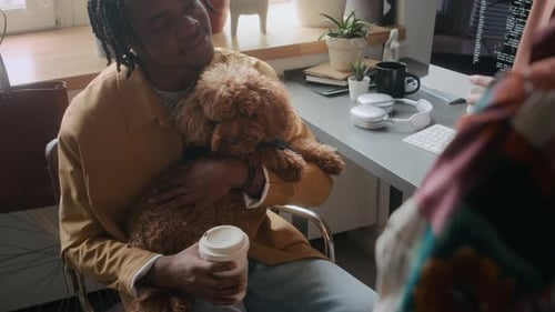 Happy Man Hugging Dog and Chatting with Colleagues during Office Coffee Break