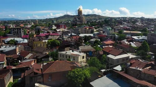 Aerial: Tbilisi city centre with Metekhi Church in background, Georgia capital