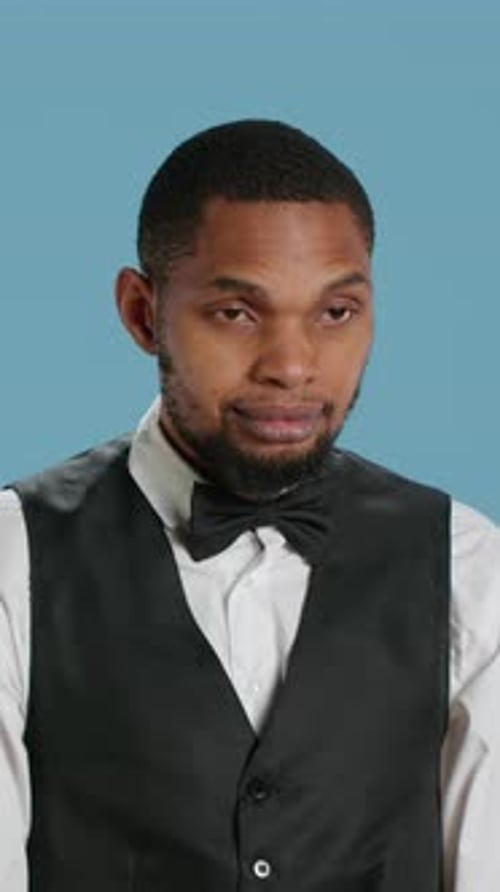 Vertical Video Portrait of Bellhop Hotel Employee Posing with Arms Crossed