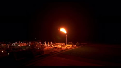 Gas flaring Illuminates the Surrounding Area with its Radiant Light - Drone Flying Forward
