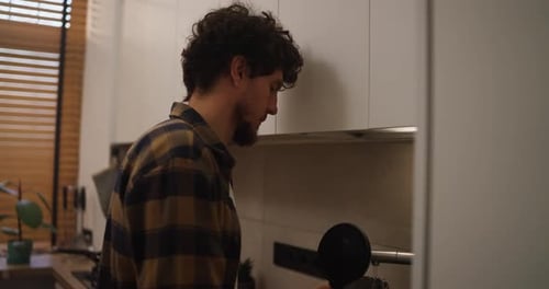 Man Makes Coffee in Modern Minimalist Kitchen