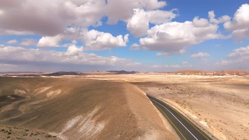 Empty Desert highway mountain road with Blue cloudy sky