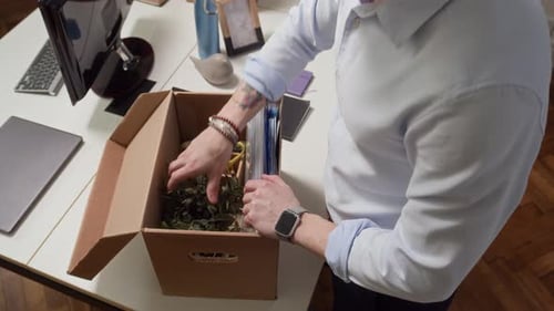 Employé déballant des objets de la boîte tout en organisant son bureau et son lieu de travail, grand angle