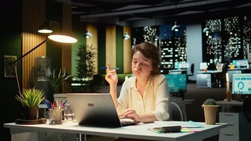 Businesswoman Wondering About Possible Solutions to a Dilemma with Laptop