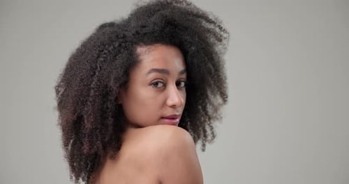 Woman Posing with Curly Hair Over Shoulder