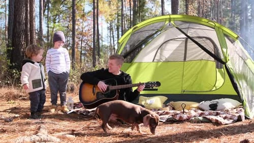 Father Plays Guitar For Children While Camping