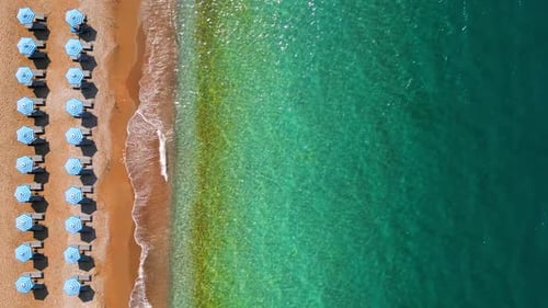 Topdown View of Sandy Beach with Sun Umbrellas and Turquoise Sea Water