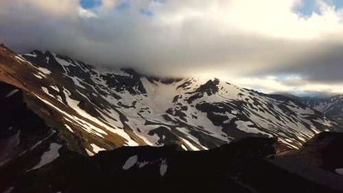 Vue aérienne des montagnes autrichiennes, des sommets enneigés touchant le paysage nuageux