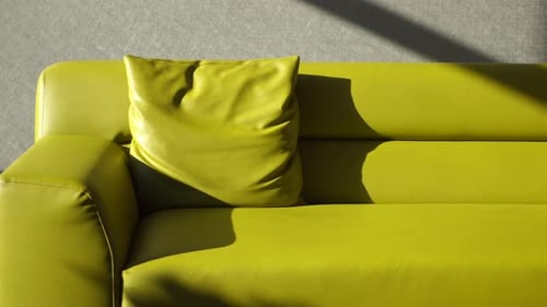 Modernes gelbes Sofa mit Kissen im heimischen Wohnzimmer