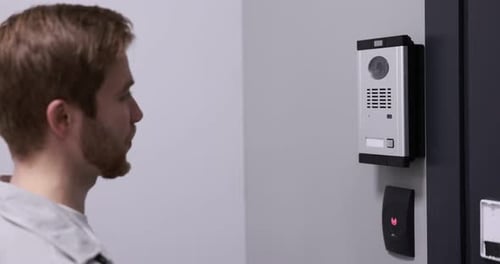 Homme appuyant sur le bouton du panneau d'interphone à l'intérieur