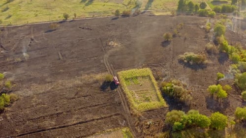 Dry grass field on fire. Aerial view of fireman truck working on the field on fire