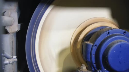 Machine with Round Rotating Part Operates at Plant Closeup